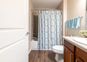 Thumbnail 20 of 55 - A bathroom with a toilet, sink, and shower curtain.