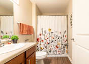 Thumbnail 22 of 55 - A bathroom with a floral shower curtain and a towel hanging on the towel rack.