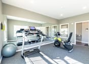 Thumbnail 35 of 55 - A home gym with a treadmill, exercise bike, and weights.