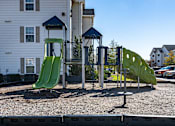 Thumbnail 42 of 55 - A playground with a green slide and a blue roofed structure.