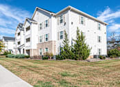 Thumbnail 44 of 55 - A white apartment building with a clear blue sky above it.
