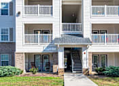 Thumbnail 49 of 55 - A white apartment building with a black roof and a sign that says "Squaker Way".