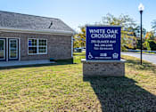 Thumbnail 55 of 55 - A sign for White Oak Crossing stands in front of a building.