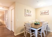Thumbnail 9 of 55 - A dining room with a wooden table and chairs.