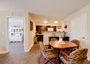 Thumbnail 15 of 27 - a dining area with a table and chairs and a kitchen in the background