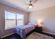 Thumbnail 19 of 27 - a bedroom with a bed and a ceiling fan