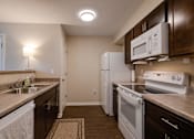 Thumbnail 16 of 27 - a kitchen with white appliances and brown cabinets