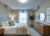 Thumbnail 42 of 43 - A well-lit bedroom with a large bed and a wooden dresser.