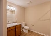 Thumbnail 12 of 32 - A bathroom with a toilet, sink, and mirror.