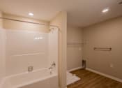 Thumbnail 13 of 32 - A white bathtub with a shower head and a towel bar.