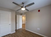 Thumbnail 14 of 32 - A room with a ceiling fan and two doors.