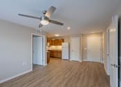 Thumbnail 15 of 32 - A room with a ceiling fan and wooden flooring.
