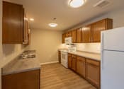Thumbnail 1 of 32 - A kitchen with wooden cabinets and a white refrigerator.