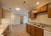 Thumbnail 4 of 32 - A kitchen with wooden cabinets and a marble countertop.