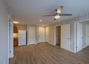 Thumbnail 5 of 32 - A room with a ceiling fan and wooden floors.
