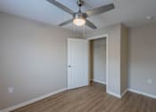 Thumbnail 7 of 32 - A room with a ceiling fan and a door.