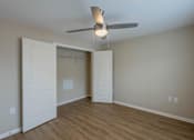 Thumbnail 9 of 32 - A room with a ceiling fan and two doors.