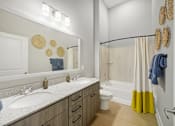 Thumbnail 7 of 20 - A bathroom with a white sink and a white toilet.