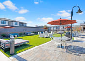 Thumbnail 16 of 25 - a patio with tables and chairs and umbrellas