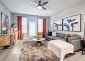 Thumbnail 3 of 25 - a living room with a couch and a ceiling fan