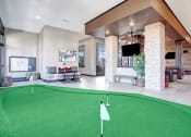 Thumbnail 22 of 25 - a putting green in the lobby of a clubhouse with a tv