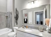 Thumbnail 13 of 25 - a bathroom with a sink and a mirror and a bath tub