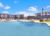 Thumbnail 25 of 25 - a resort style pool with lounge chairs and umbrellas with apartments in the background
