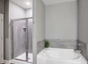 Thumbnail 5 of 25 - a white bathroom with a tub and a shower