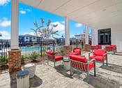 Thumbnail 18 of 25 - a covered patio with red chairs and tables and a pool