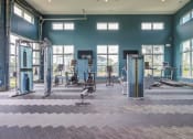 Thumbnail 15 of 28 - Gym inside with very tall ceilings, treadmills, bikes, machine weight lifting, eliptical machines and mix and match gym flooring.