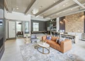 Thumbnail 17 of 28 - Resident lounge has wood beams in the ceiling, leather couch and chair in front of fireplace and flat screen TV.  Seating around a coffee bar with white granite counters.  Also, game area in the back with shuffle board and oversized checkers.