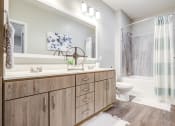 Thumbnail 8 of 23 - a bathroom with a large mirror and a toilet next to a bathtub