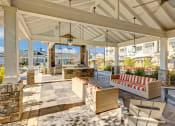 Thumbnail 20 of 28 - a covered patio with furniture and a table and chairs