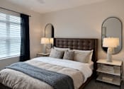 Thumbnail 8 of 14 - A bedroom with a large bed and two lamps.