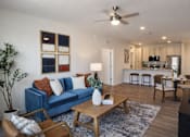 Thumbnail 1 of 14 - A living room with a blue couch and a wooden coffee table.