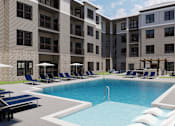 Thumbnail 12 of 14 - A large swimming pool is surrounded by lounge chairs and umbrellas in front of a building.
