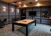 Thumbnail 15 of 21 - Resident game room with pool table, television and café seating at Argento on the Broad apartments in Arden, NC