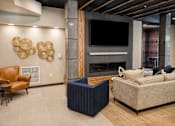 Thumbnail 17 of 21 - Resident lounge with fireplace, television and modern seating at Argento on the Broad apartments in Arden, NC