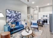 Thumbnail 6 of 25 - a living room with a blue couch and a table