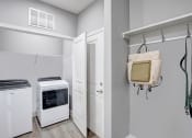 Thumbnail 12 of 25 - a laundry room with a stove and a door to a closet