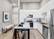 Thumbnail 10 of 25 - a modern kitchen with stainless steel appliances and white cabinets
