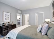 Thumbnail 8 of 25 - a bedroom with a large bed and a door to a bathroom