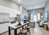 Thumbnail 2 of 25 - an open kitchen and living room with a table and chairs