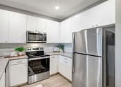 Thumbnail 11 of 25 - a kitchen with stainless steel appliances and white cabinets