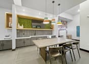 Thumbnail 13 of 20 - A modern kitchen with a wooden table and chairs.