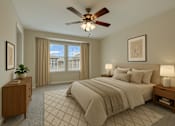 Thumbnail 5 of 16 - A bedroom with a large bed, a ceiling fan, and a window with curtains.