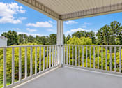 Thumbnail 8 of 22 - A white balcony with a metal railing overlooking a forest.