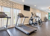 Thumbnail 16 of 22 - Treadmills, ellipticals and an exercise bike in the fitness center at Canterbury Apartments in Myrtle Beach, SC.