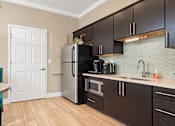 Thumbnail 19 of 22 - Office kitchenette with dark cabinets, a refrigerator, microwave and coffee station at Canterbury Apartments in Myrtle Beach, SC.