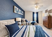 Thumbnail 5 of 22 - Furnished bedroom with two twin beds and a view of the adjoining bathroom at Canterbury Apartments in Myrtle Beach, SC.
